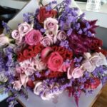 A large-sized bouquet of flowers wrapped in luxurious paper and tied with ribbon by Petals Gourmet Flowers.