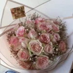 A medium-sized bouquet of flowers wrapped in luxurious paper and tied with ribbon by Petals Gourmet Flowers.